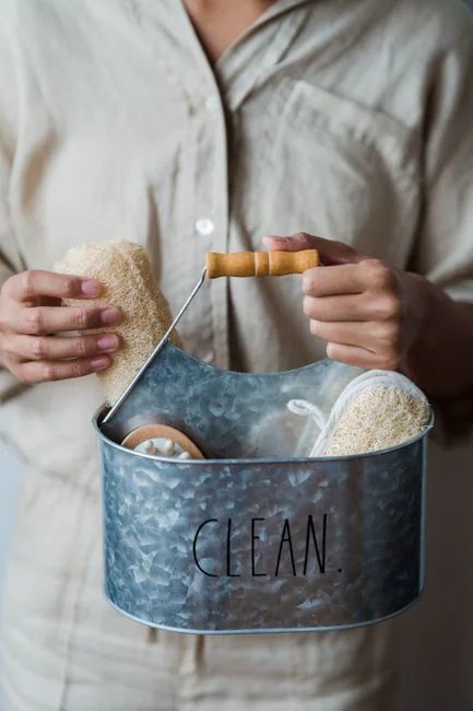 A uniformed housekeeper expertly tidies the bed linens in an upscale hotel room.
